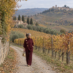 Carolina completo in maglia bordeaux, donna italiana tra i vigneti in autunno, maglia con tre bottoni dorati e pantaloni ampi