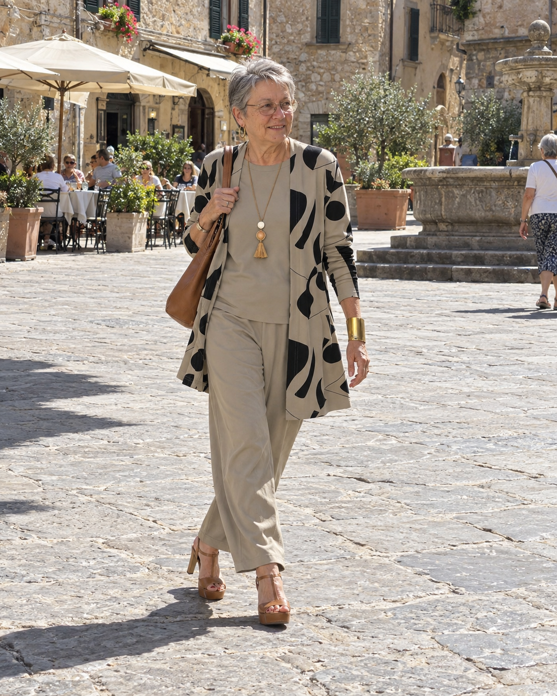 Donna italiana su una piazza di paese con completo tre pezzi tortora e cardigan stampato