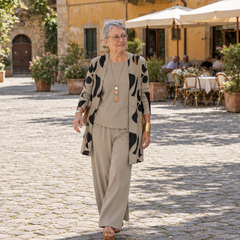 Donna italiana che attraversa una piazza con completo tre pezzi tortora e cardigan stampato aperto