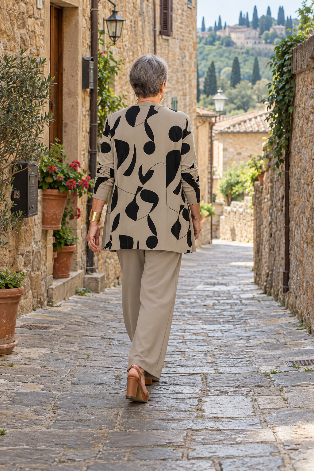 Completo tre pezzi tortora con cardigan stampato visto da dietro in un vicolo italiano