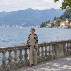 Donna italiana in sosta vicino al lago con completo tre pezzi tortora e cardigan stampato